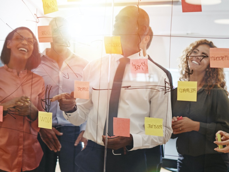 Diverse coworkers brainstorming together with sticky notes in an
